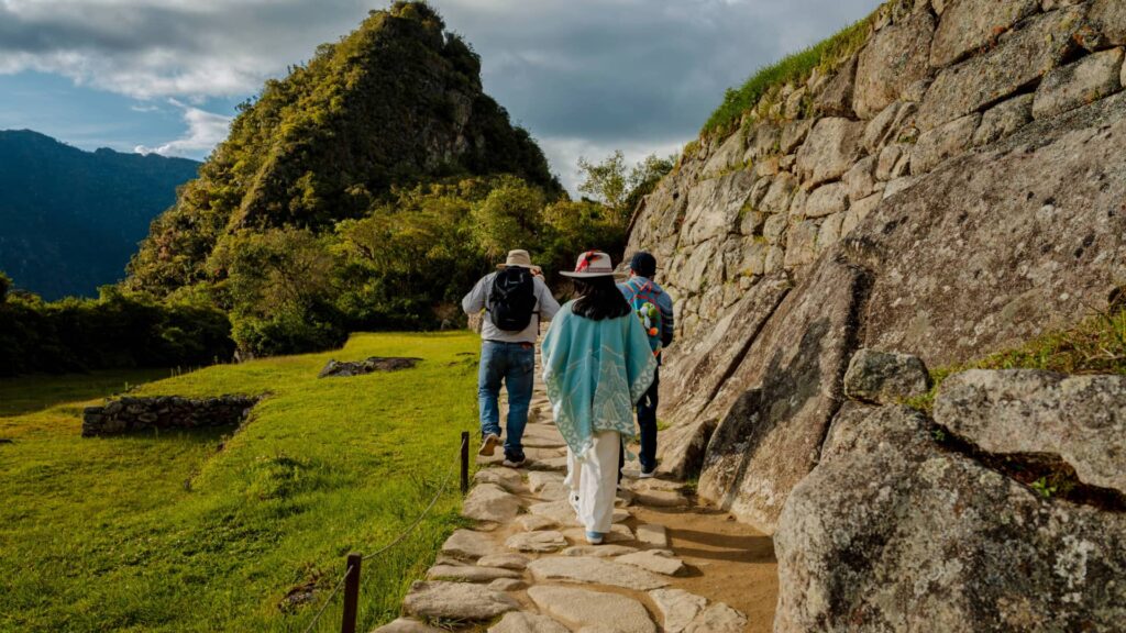 Tourists exploring Machu Picchu ruins with mountains in the background